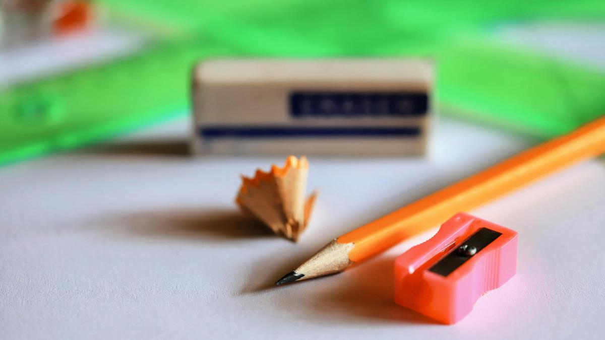 Un lápiz, borrador y sacapuntas sobre un cuaderno.