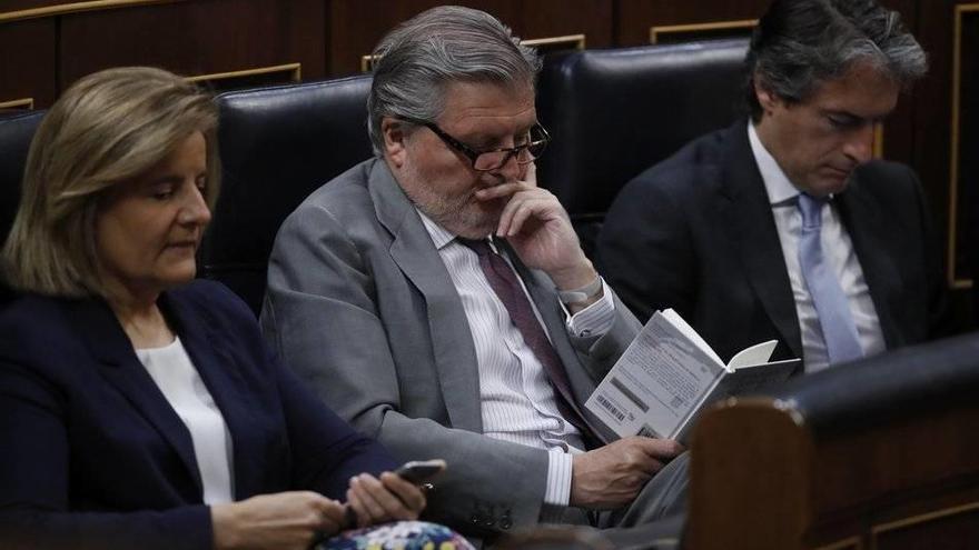 Los ministros, de Empleo, Fátima Báñez; de Educación, Íñigo Méndez de Vigo (c), y de Fomento, Íñigo de la Serna (d), durante la intervención de Montero.