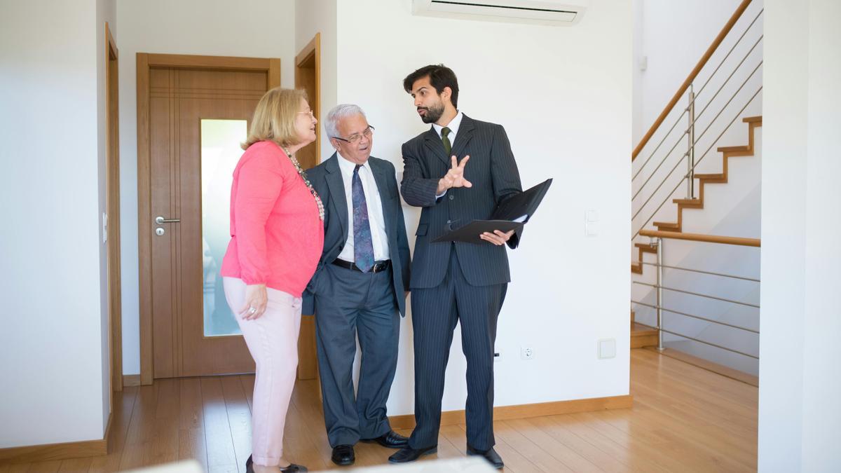 Un agente inmobiliario enseñando una vivienda a unos clientes