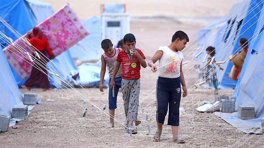 Un grupo de niños iraquíes caminan por un campamento de refugiados cerca de Irbid.