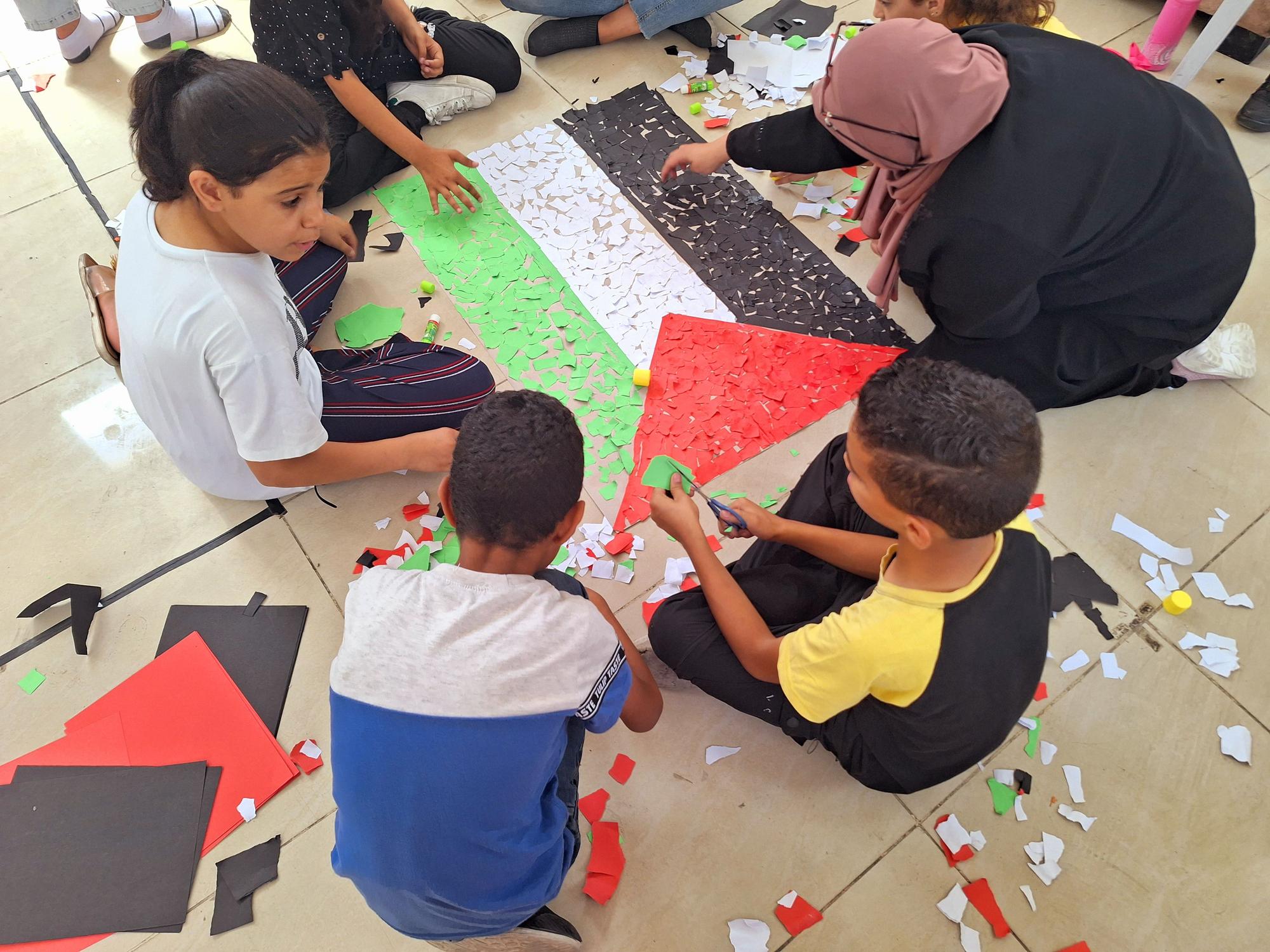 Niños y niñas de campos de refugiados de Cisjordania, en una actividad de collage.