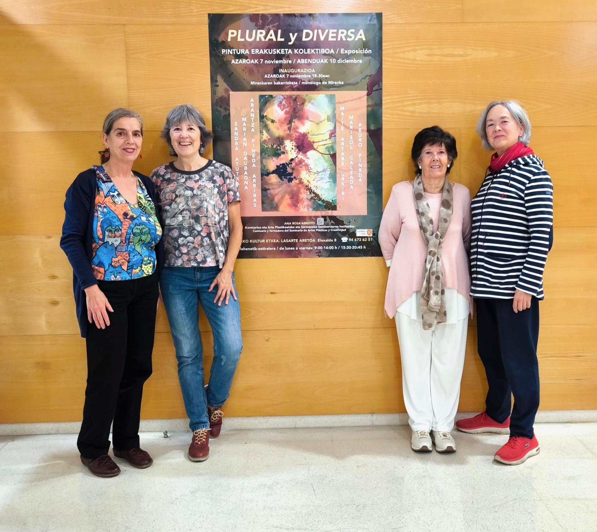 La comisaria de la exposición Ana Rosa Arroyo mostrando el cartel con Marian Daubagna, Marisol Calzada y Maite Artabe Urkiri