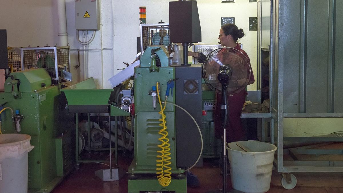 Una trabajadora maneja una maquinaria en una fábrica.