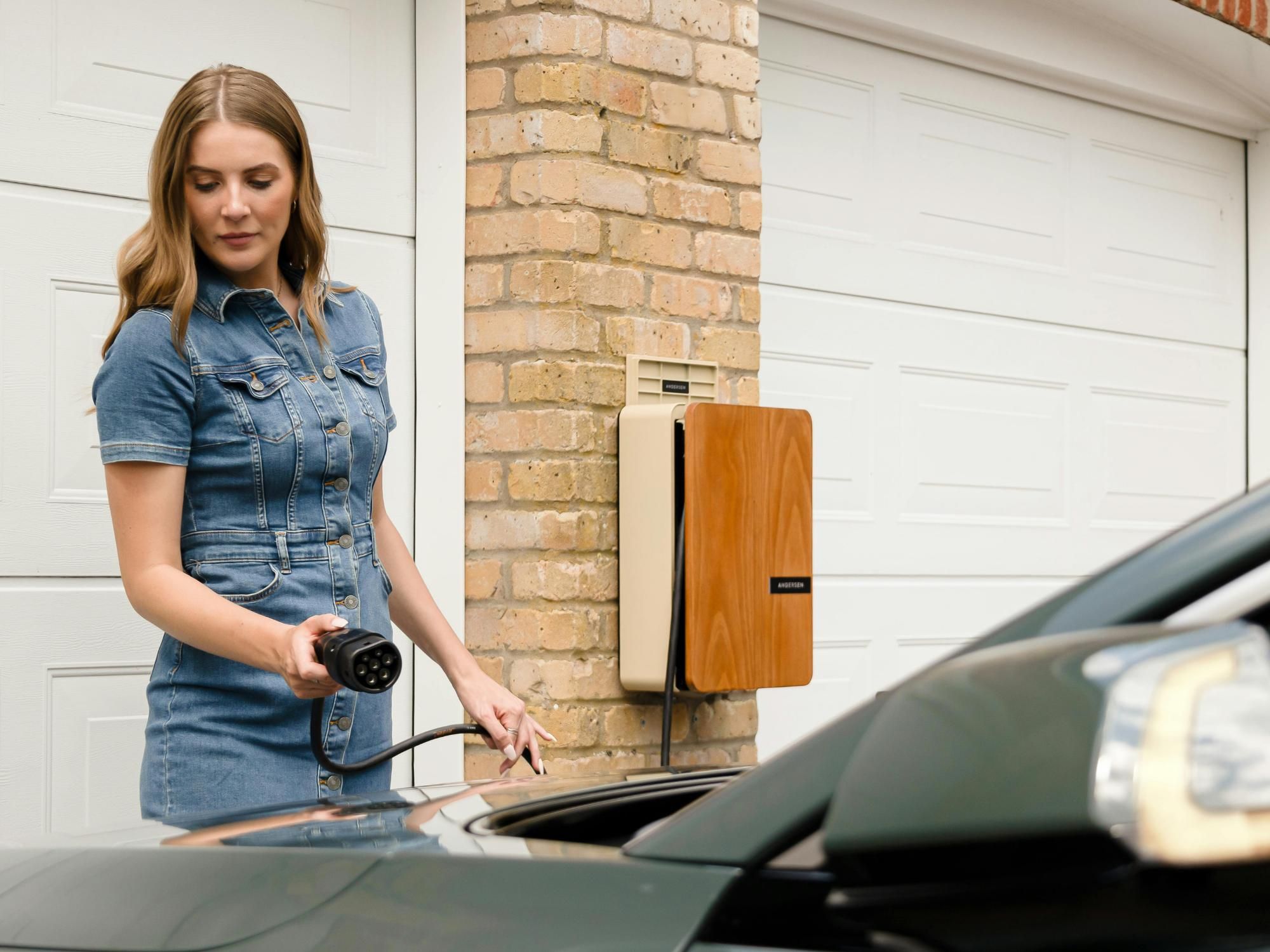 Mujer cargando su coche eléctrico en su casa
