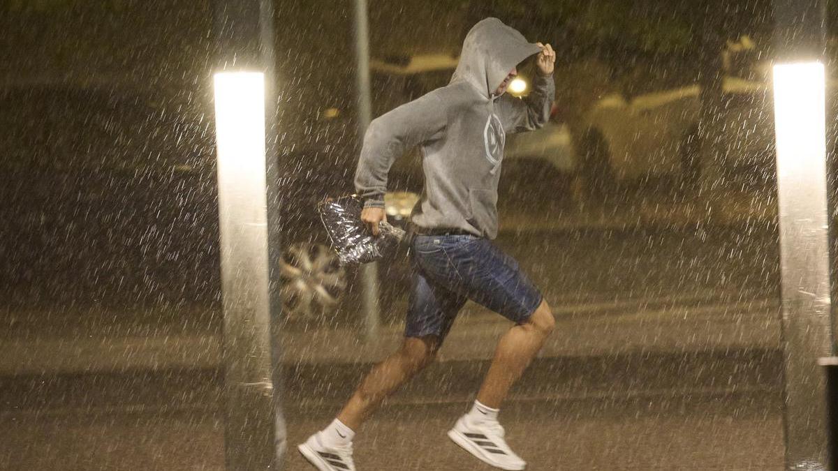 Un joven trata de protegerse de la lluvia en una imagen de archivo