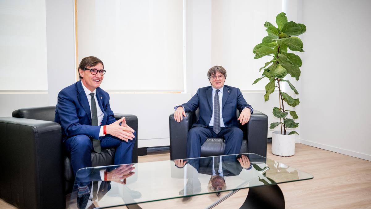 El presidente de la Generalitat, Salvador Illa, saluda al presidente de Junts per Catalunya, Carles Puigdemont.