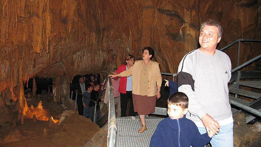 Un grupo de personas de Lekunberri y Larraun observando las formaciones creadas por el agua en la roca de las cuevas de Mendukilo