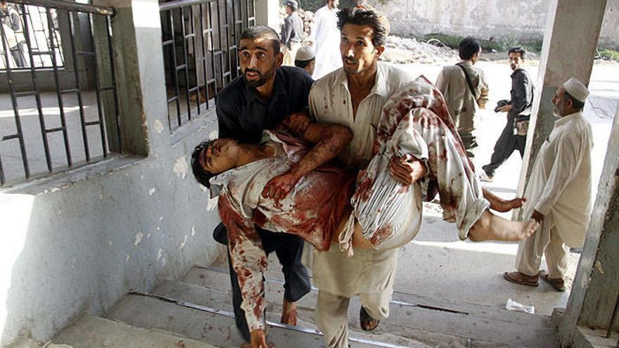 Un hombre herido, víctima del doble ataque suicida realizado hoy, viernes 13 de mayo de 2011, es llevado a un hospital de Peshawar (Pakistán).