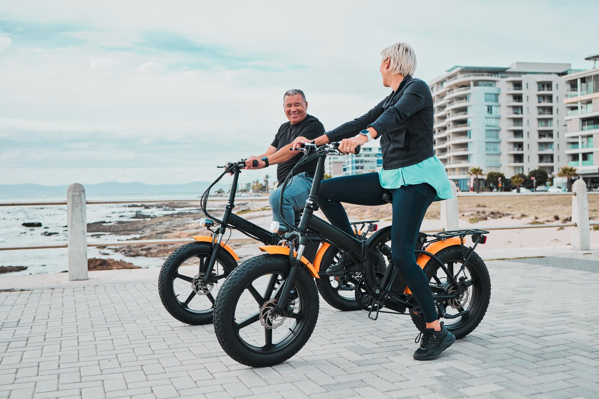 Una pareja adulta pasea con bicis eléctricas.