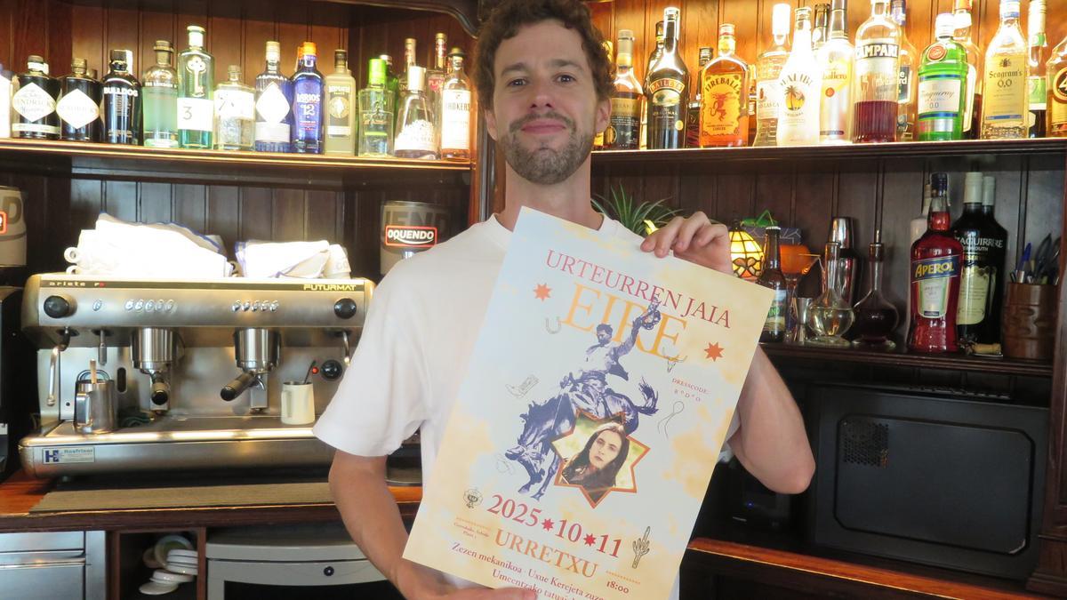 Julen Izagirre, en el bar Eire, con el cartel que anuncia la fiesta de aniversario.