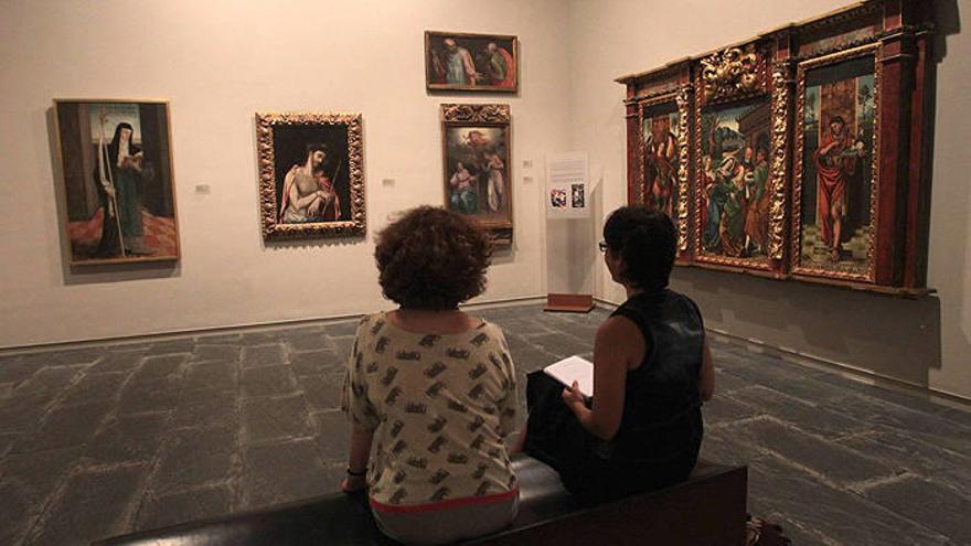 Visitantes contemplan las pinturas en la sala que el Museo de Navarra dedica a artistas coetáneos del Greco.