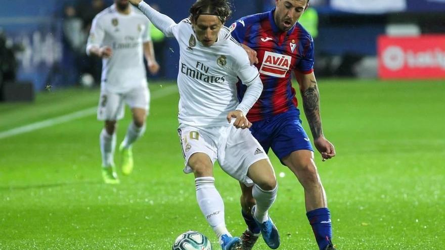Luca Modric disputando un balón junto a Sergi Enrich.