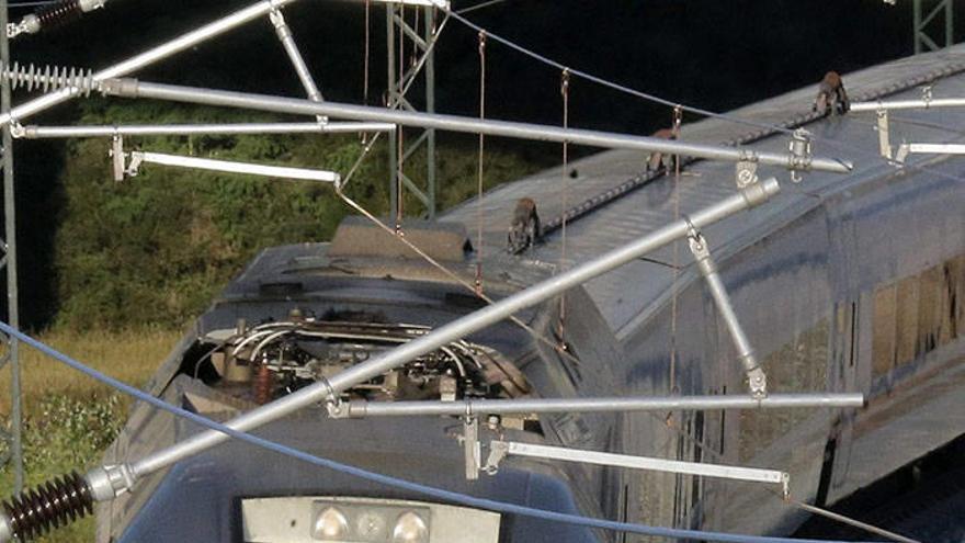 Los vecinos de Angrois reciben la llegada del tren con cirios y el conductor les responde con un saludo.