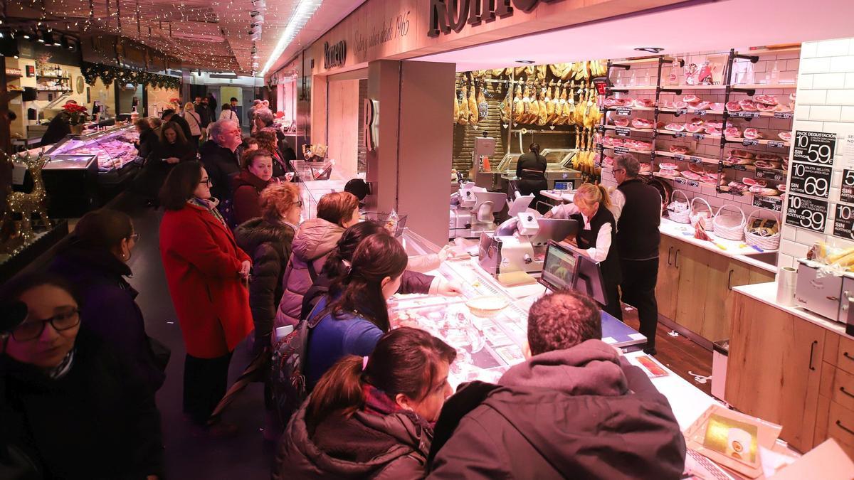 Clientes comprando en los puestos del mercado del Ensanche