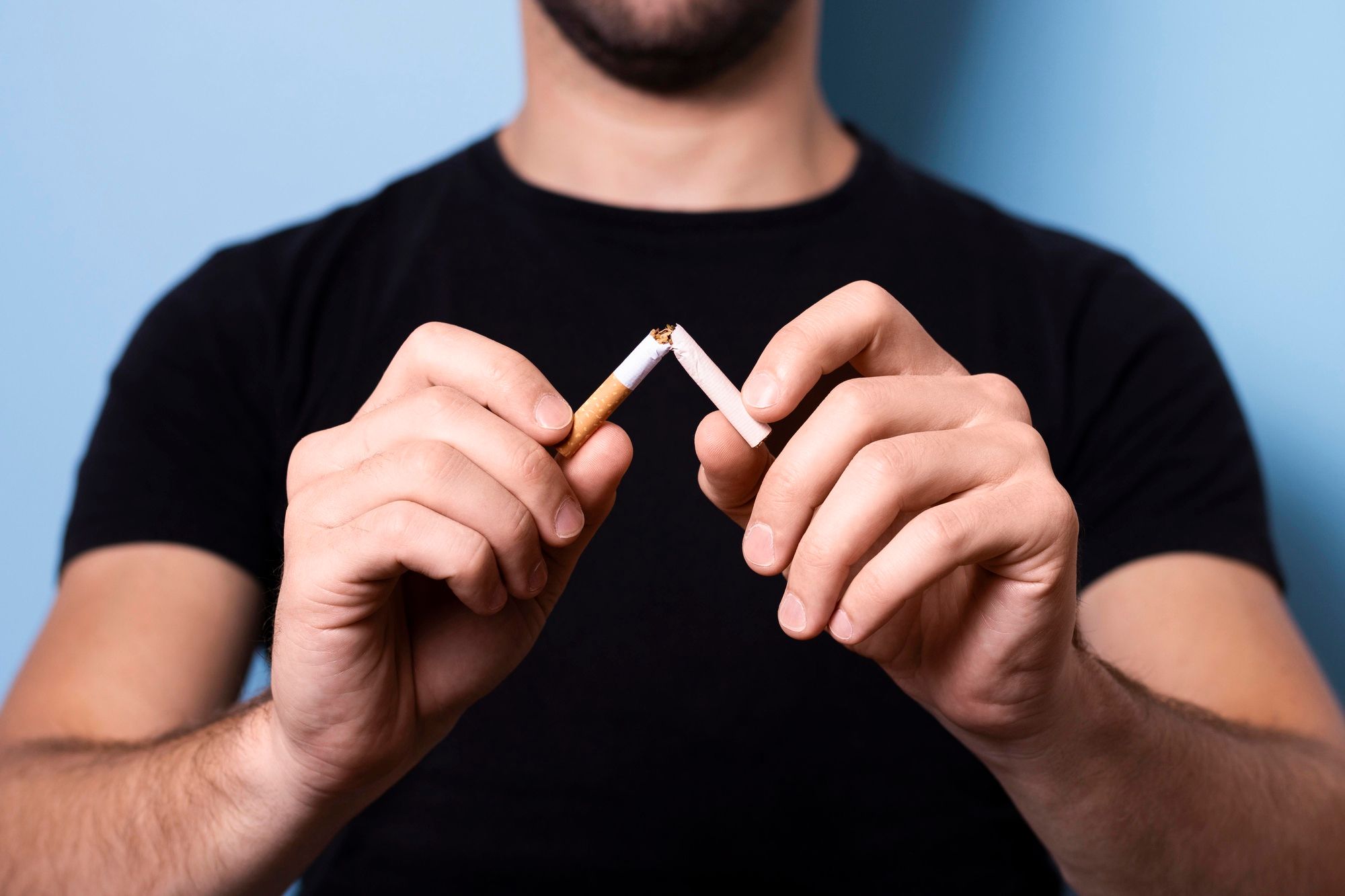 Un adulto parte un cigarrillo en dos.