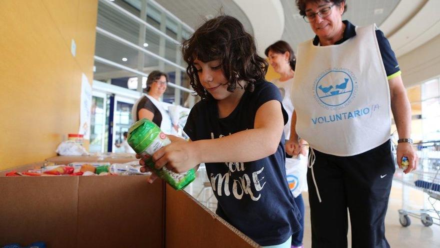 Clientes de E. Leclerc donando comida a los voluntarios de la Gran Recogida del Banco de Alimentos de Navarra (BAN).