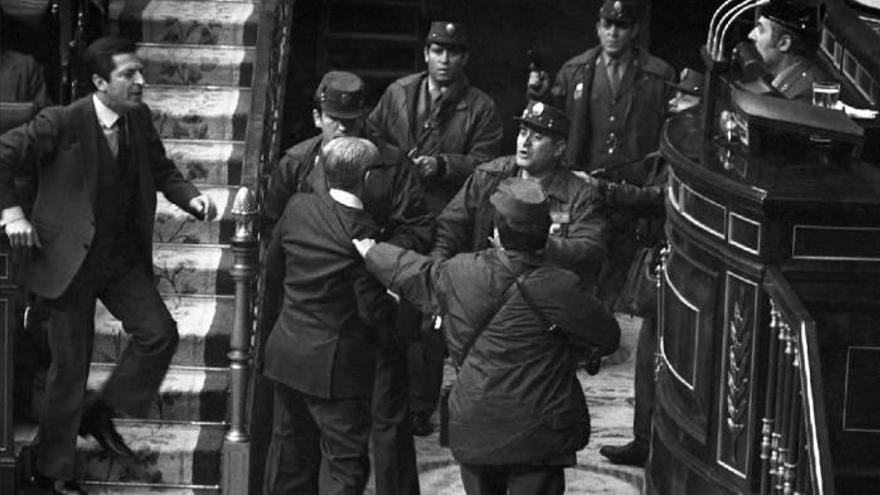 El vicepresidente y teniente general Manuel Gutiérrez Mellado forcejea con un grupo de guardias civiles, mientras el presidente Adolfo Suárez sale a ayudarle.