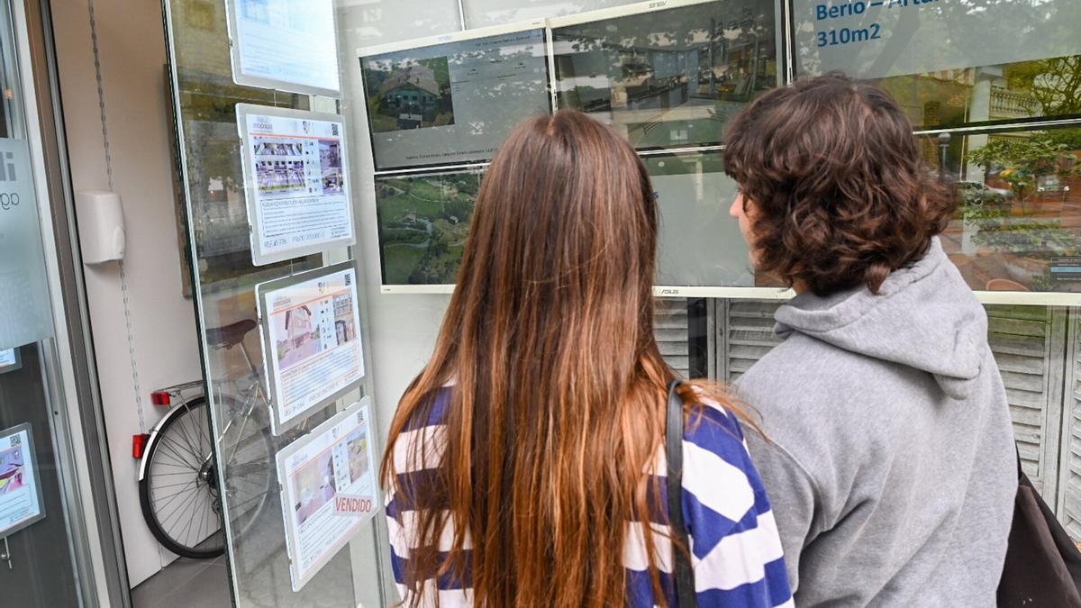 Dos jóvenes buscan casa en inmobiliarias de Donostia.