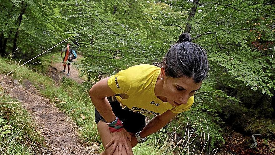 Una corredora apoyándose en sus piernas para ayudarse a avanzar.