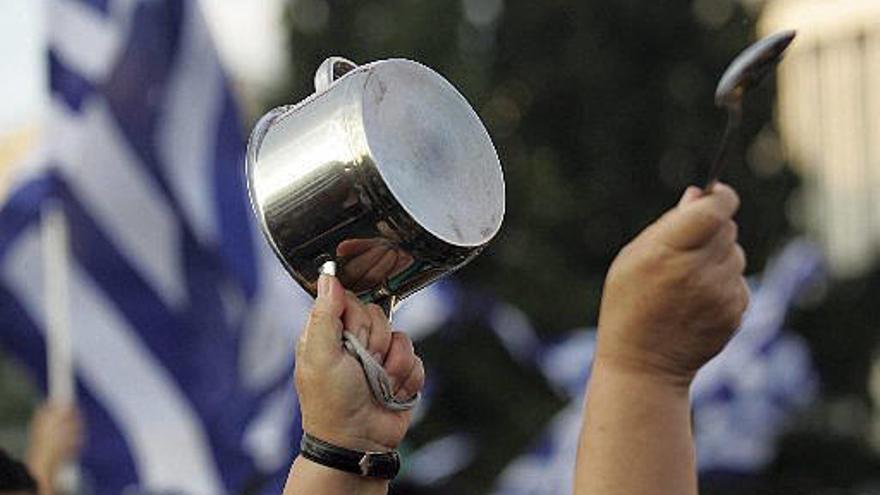 Ciudadanos griegos protestan con una cacerolada en la plaza Sintagma de Atenas (Grecia).