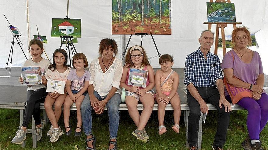 Participantes de la II edición del Concurso de Pintura al Aire Libre con las obras detrás.