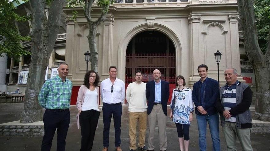 Los responsables del proyecto de restauración y personal de la Casa Misericordia, ayer frente a la puerta principal del coso pamplonés.