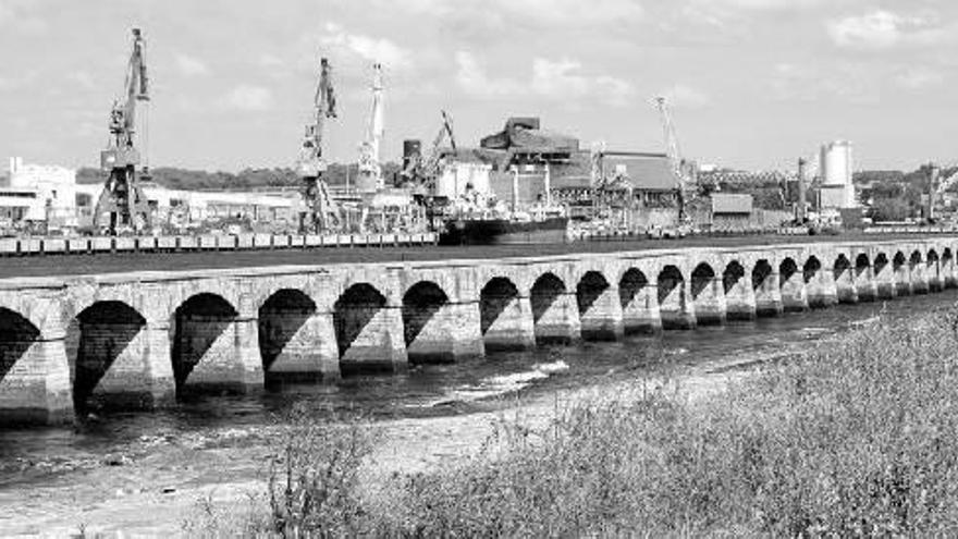 Instalaciones del puerto de Baiona, con silos y grúas al fondo.