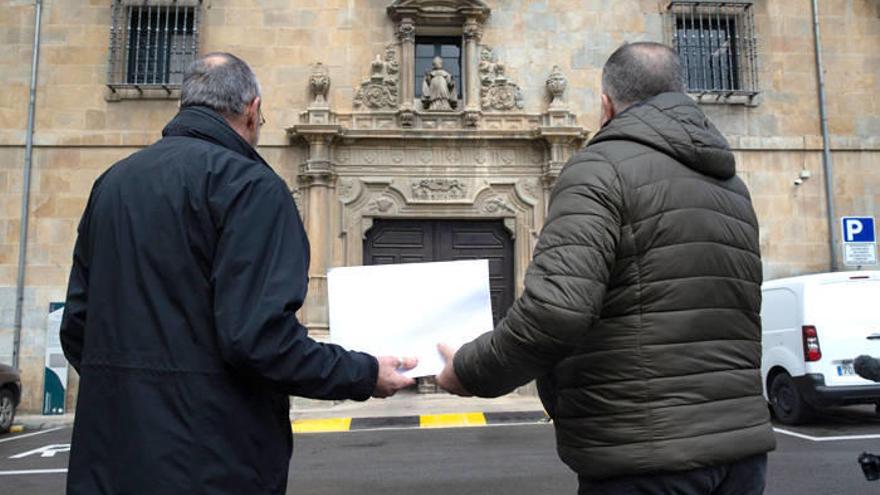 Estanislao y Guillermo (nombres ficticios) sujetan la carta frente al Arzobispado de Pamplona.