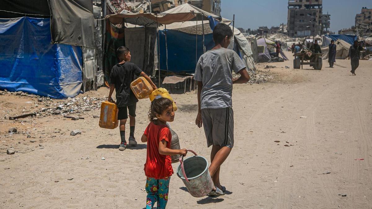 Varios niños buscan agua en un campamento de refugiados al oeste de la ciudad de Gaza.