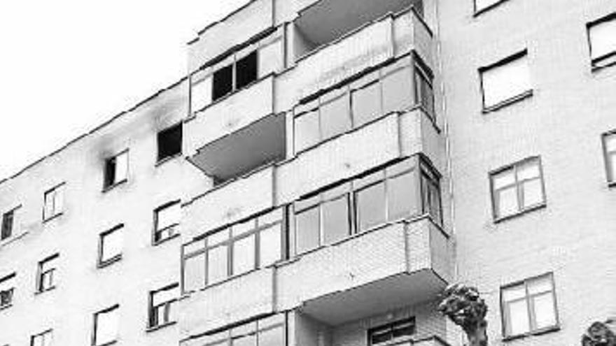 Dos vecinos miran al piso incendiado, en la última planta.