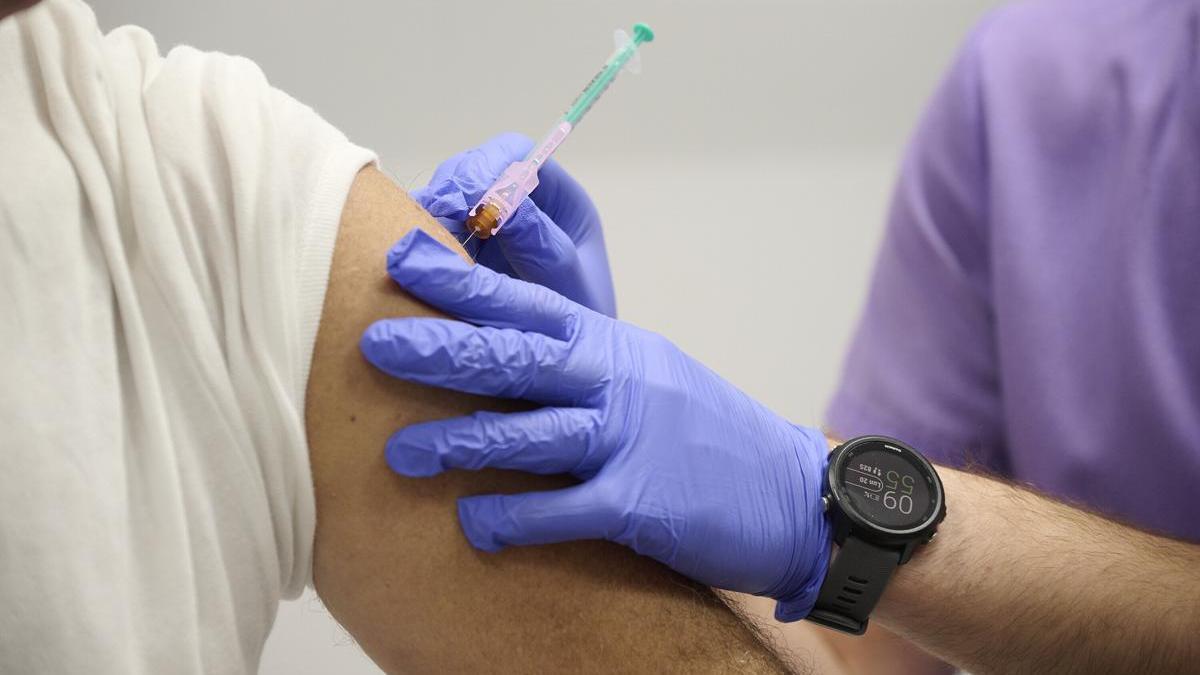 Imagen de detalle de un enfermero poniendo una vacuna