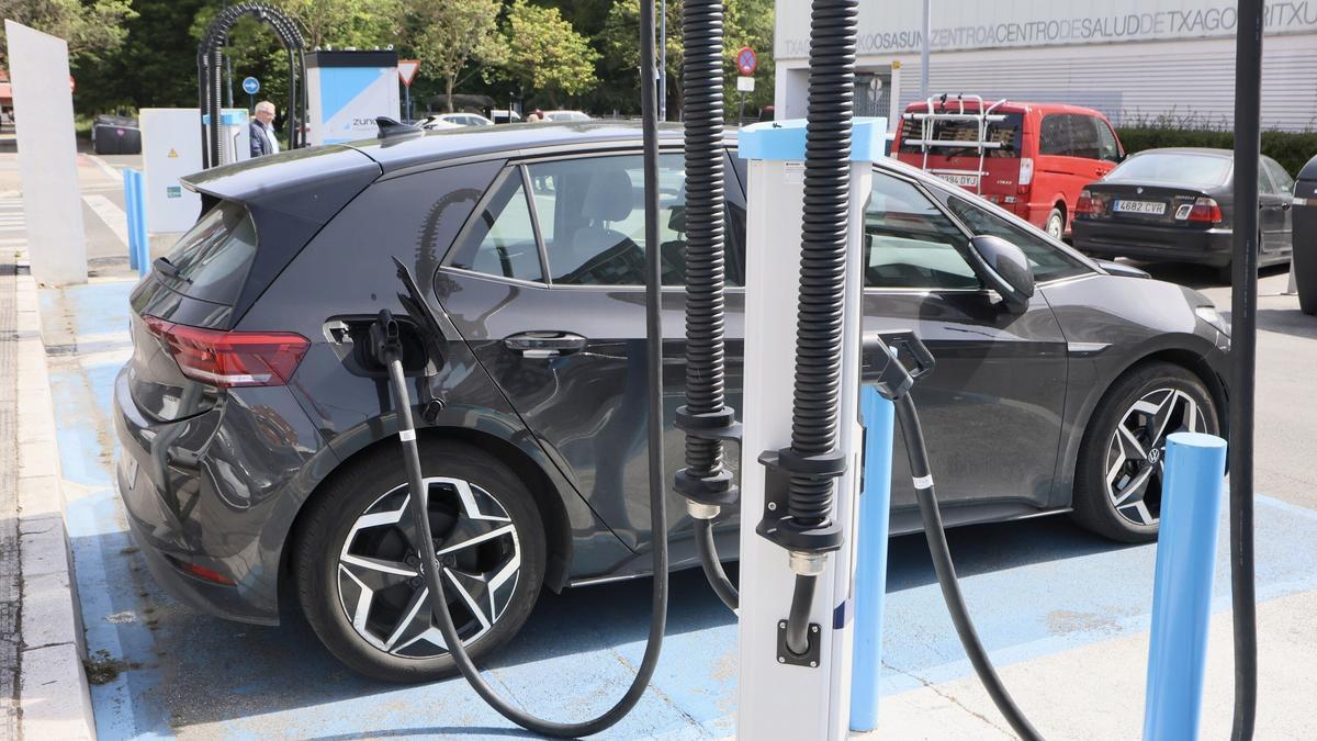Un coches eléctrico recargando su batería en un puesto.