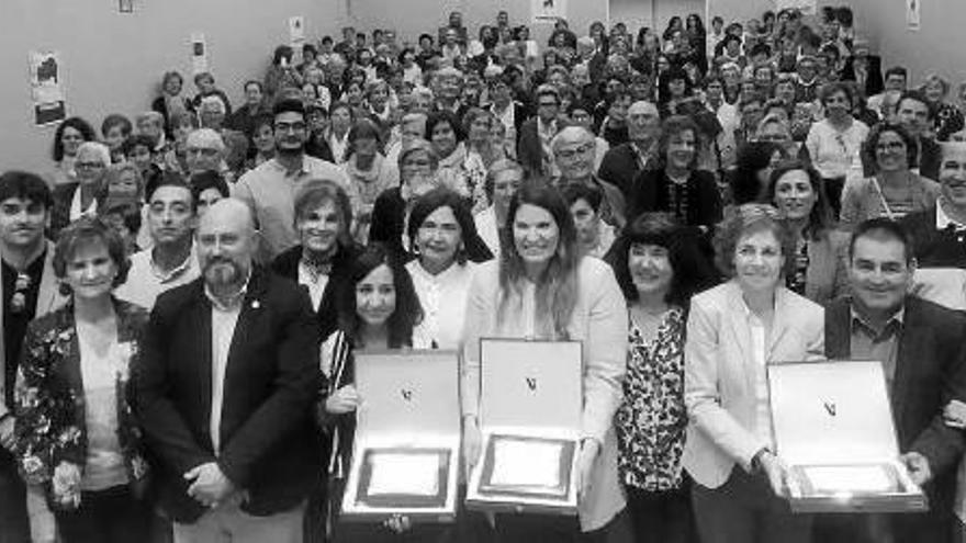 Las personas galardonadas posan junto con los representantes de las distintas instituciones y el público asistente.