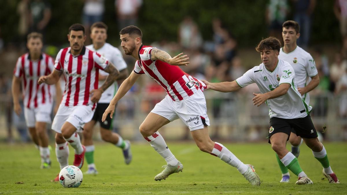Un futbolista del Racing intenta frenar a Ohian Sancet durante el partido del miércoles ante los cántabros en Muriedas.