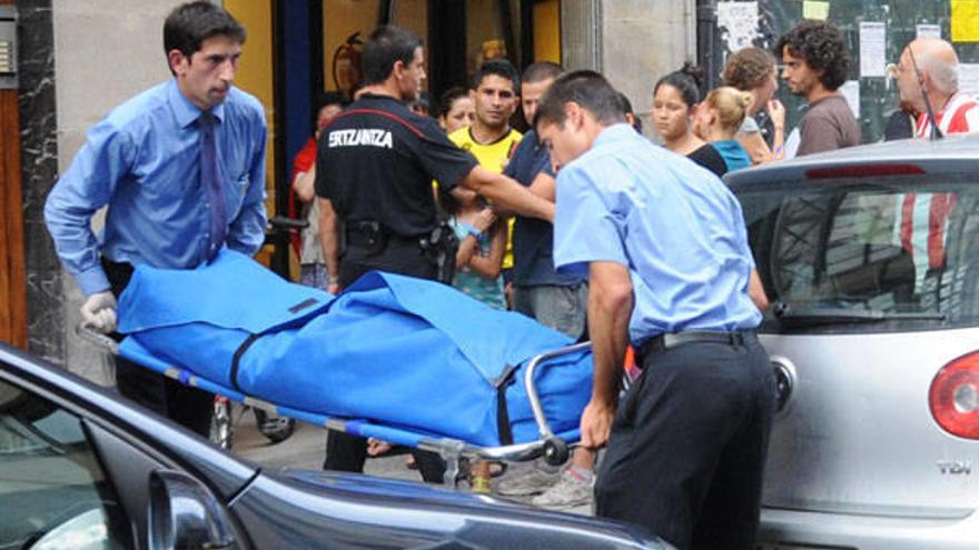 Miembros de los servicios funerarios trasladan el cuerpo de Deisy, de 36 años, que murió ayer tras recibir siete puñaladas, presuntamente, de su marido.