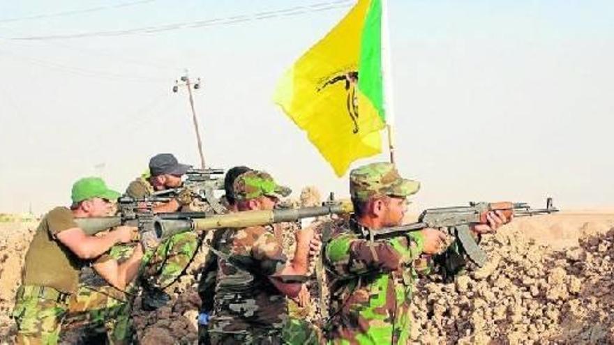 Voluntarios chiíes de la milicia Brigadas de Hizbulá toman posiciones mientras combaten contra militantes del grupo Estado Islámico.