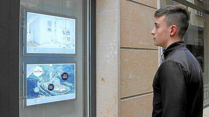 Un joven observa la oferta de pisos en el escaparate de una inmobiliaria de Elgoibar.