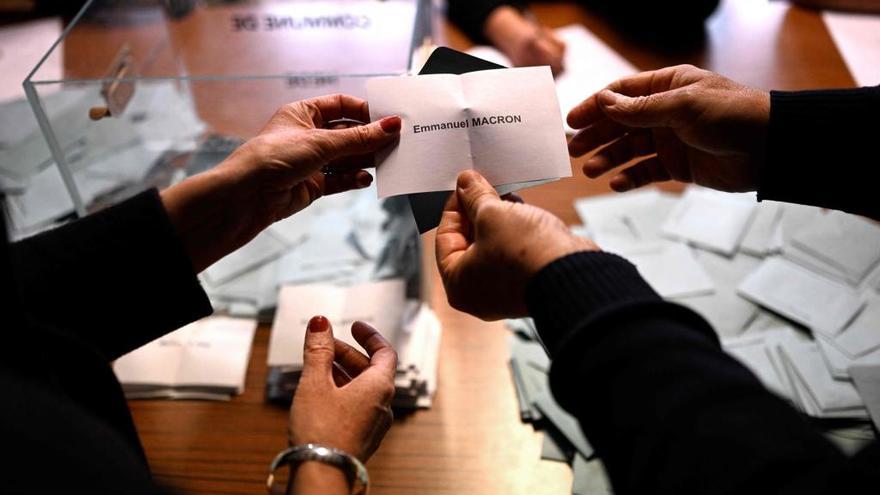 Dos personas cuentan los votos en una mesa electoral.