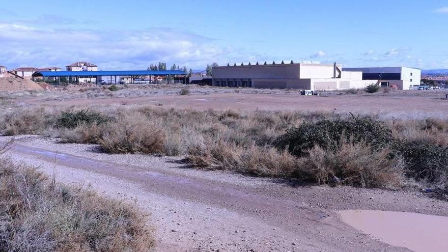 Terrenos donde se instalará el complejo deportivo, al fondo las piscinas del Clara Campoamor.