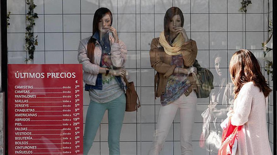Una mujer mira el escaparate de una cadena de tiendas de moda en el Ensanche de Pamplona.