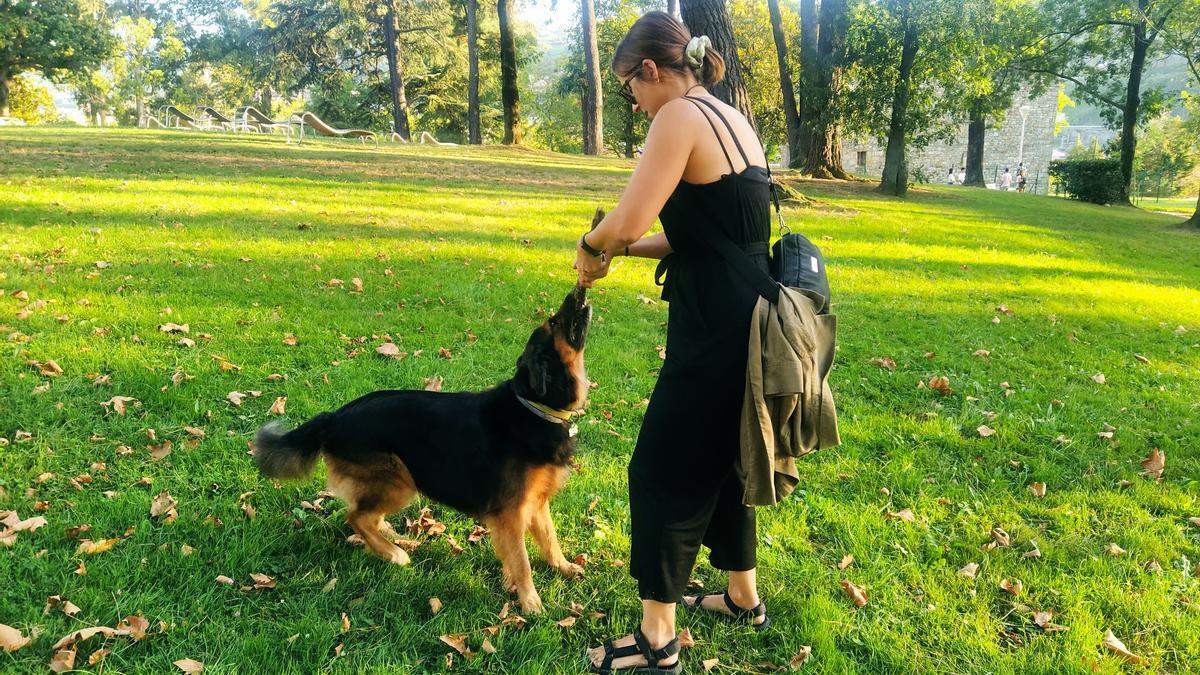 Una joven juega con su perro en un parque. Una joven juega con su perro en un parque.