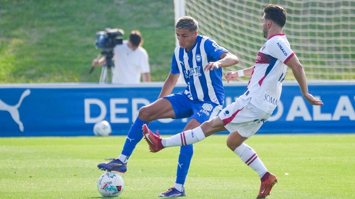 Tenaglia controla un balón frente a la presión de un futbolista oscense.