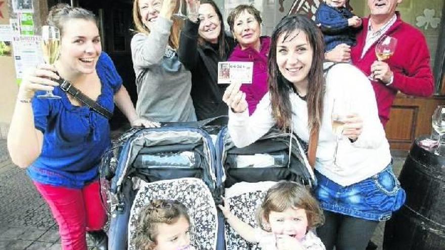 Ainhoa muestra orgullosa junto a varios integrantes de su familia y otros agraciados con el tercer premio de la lotería su décimo premiado.