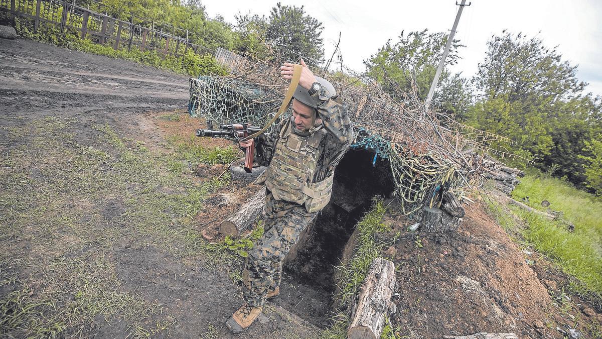 Un soldado ucraniano sale de una trinchera en un bosque de Ucrania.