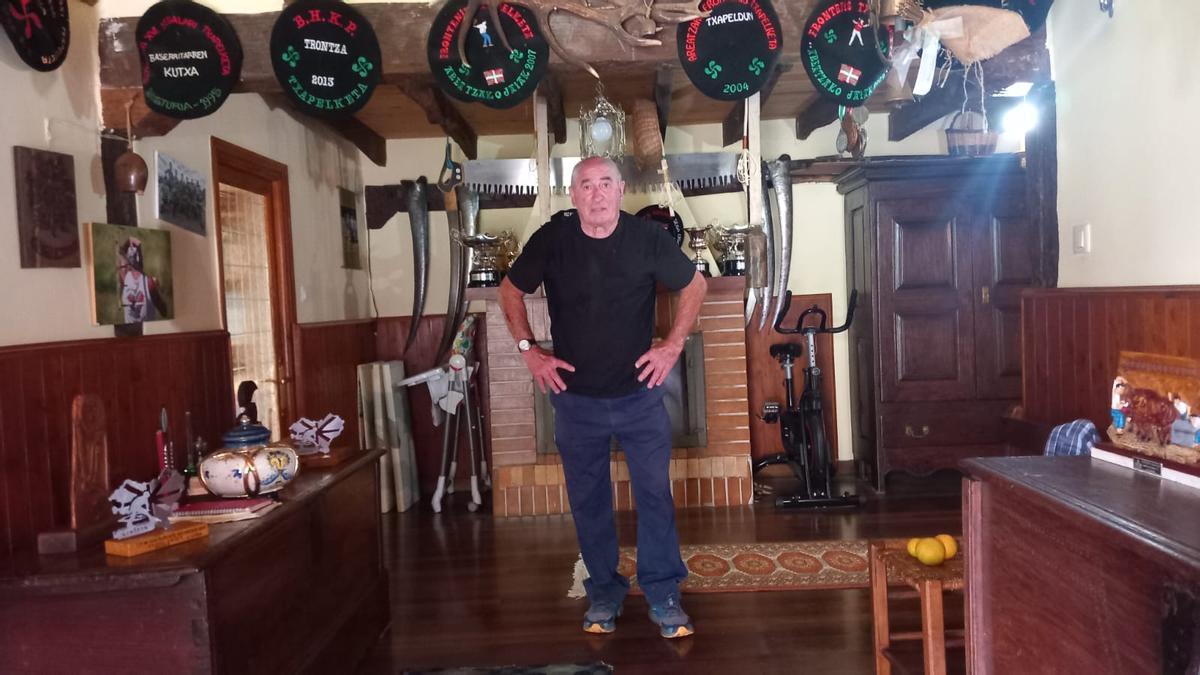 Pabi en su caserío con algunos de los cientos de trofeos que posee.
