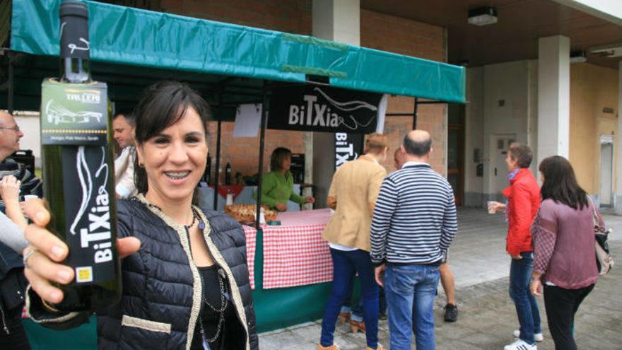 Una joven muestra una botella de una de las bodegas txakolineras presentes en la feria.
