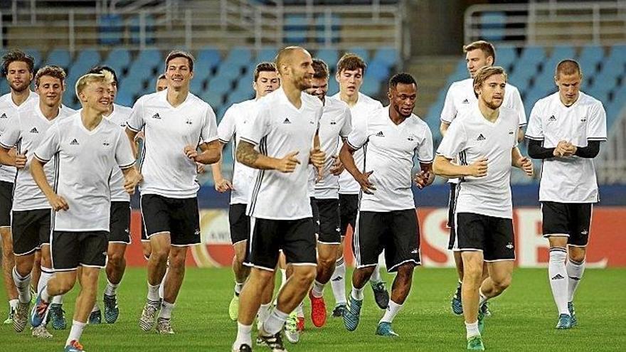 Los futbolistas del Rosenborg calientan en grupo durante un entrenamiento.