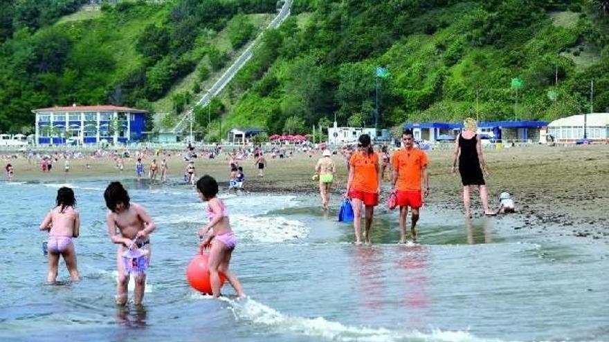 Varias personas se bañan en un playa.