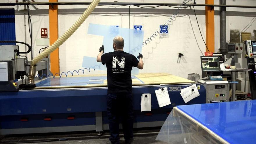 Un trabajador en una empresa de fabricación de mamparas protectoras de metacrilato.