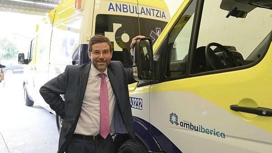 El director general de Ambuiberica posa junto a las nuevas ambulancias del servicio.